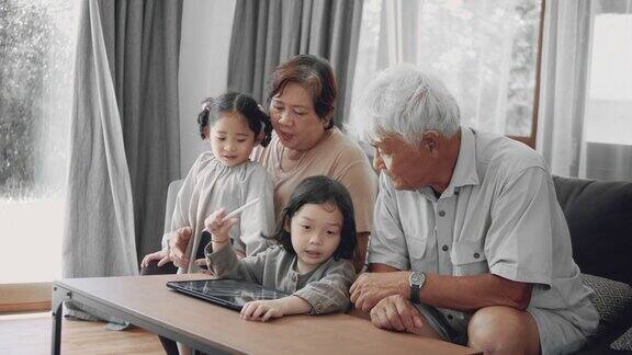 亚洲男孩在家和祖父母一起上网络课
