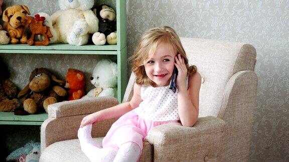 小女孩坐在椅子上正在讲手机快乐微笑
