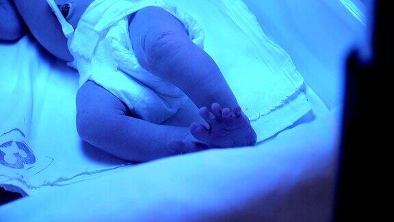 保育箱里的早产儿刚出生的可爱的婴儿与手夹在脐带在医院托儿所高清