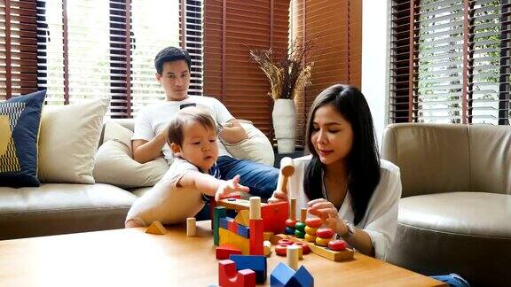 年轻的亚洲家庭一起呆在家里的客厅里