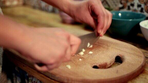女人用刀切新鲜的大蒜