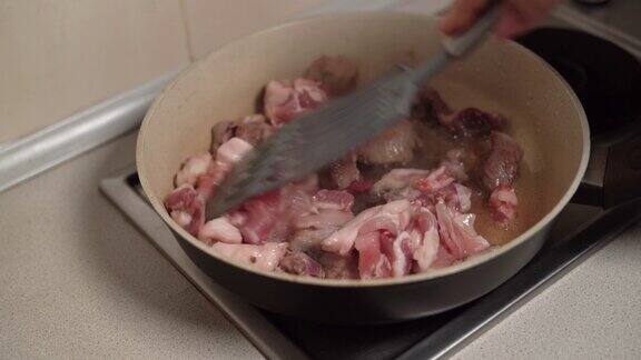 猪肉切成块用锅铲搅拌然后在平底锅里用油煎不健康食品