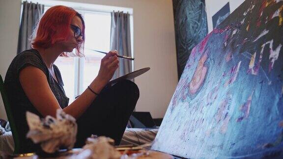 红发白人少女艺术家在她的房间里用油画颜料作画