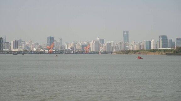 从徐汇滨江公园眺望上海外滩蓝天背景下的摩天大楼黄浦江上的货船4K视频慢镜头