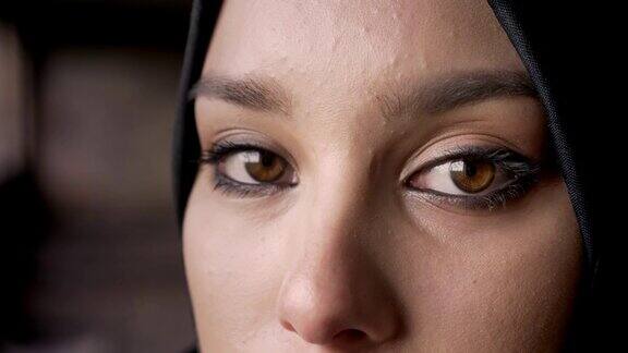 近距离拍摄的年轻穆斯林妇女戴着头巾看着镜头的眼睛悲伤和沮丧的表情