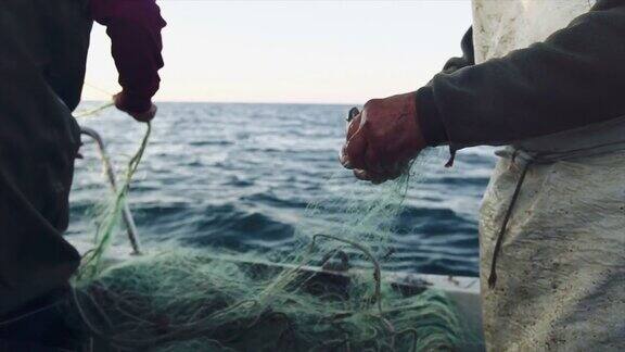 渔民在渔船上工作:拉网