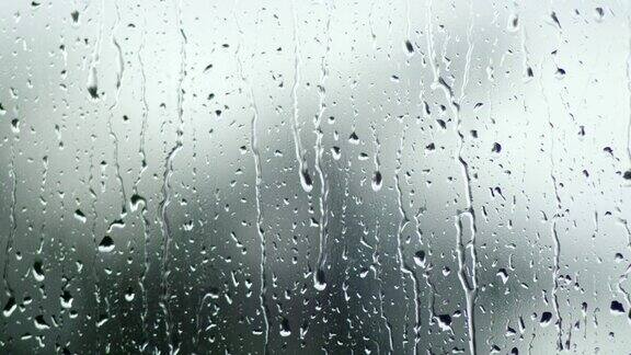 雨滴落在玻璃上阴天背景模糊