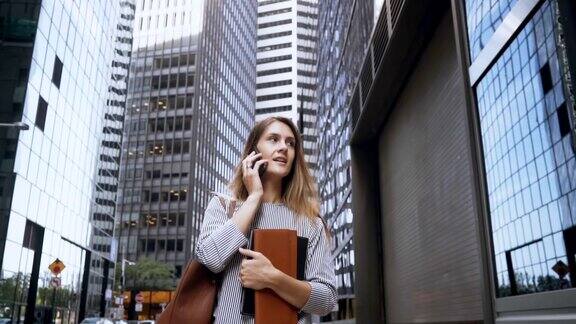 年轻忙碌的女商人一边打电话一边在纽约金融区工作缓慢的莫
