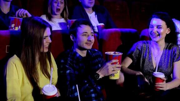 青少年坐在电影院里看喜剧吃爆米花喝可乐