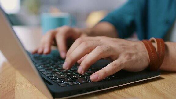 男人的手在笔记本电脑键盘上打字的特写