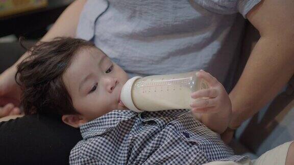 在家里用奶瓶喂亚洲男婴