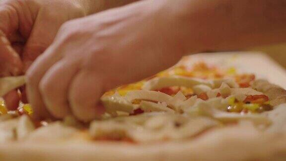 近距离的一个披萨厨师的手填高质量的意大利美食成分的披萨