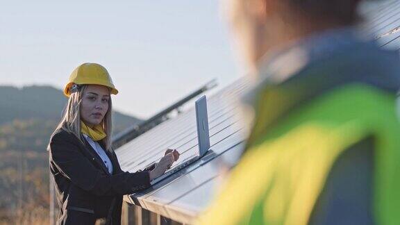 在太阳能发电厂工作的女工程师团队合作可再生能源系统太阳能城市
