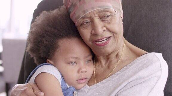 老年妇女与癌症慈爱地抱着孙女
