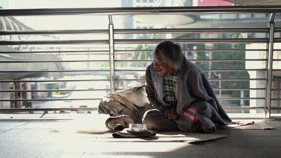 无家可归的人坐在人行道上咳嗽