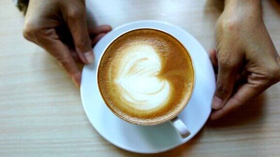 咖啡师的手显示拿铁艺术咖啡准备喝