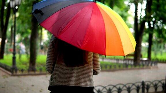 一个不认识的女人在雨下跑在城市公园的背影Slowmotion拍摄