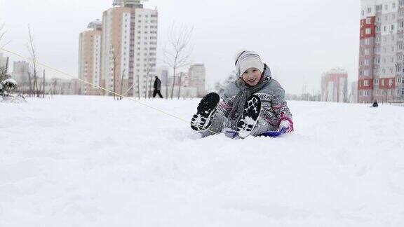 在寒冷的冬天一个快乐的女孩在白雪上驾着雪橇