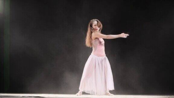 美丽的芭蕾舞演员在粉雪中跳舞