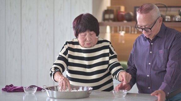 中国老年妇女准备中国食物“汤圆”糯米团为中国新年团圆饭