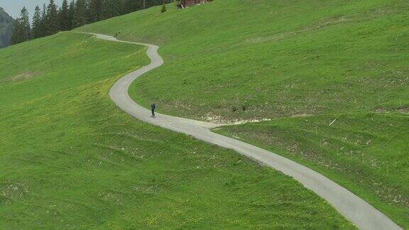 年轻的成年男子滑板偏僻的高山公路与山景