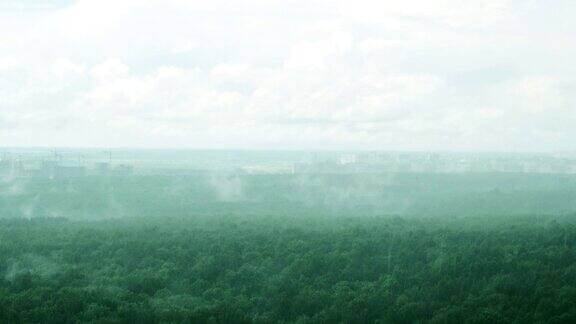 在薄雾笼罩的地平线上夏雨笼罩着森林和城市