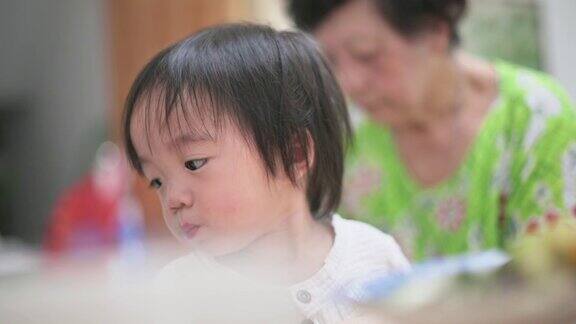 亚洲华人祖母在家里喂可爱的男婴