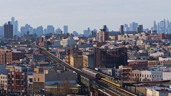 从住宅区俯瞰布鲁克林市中心的远景一列火车正从地铁高架线沿默特尔大道开往布鲁克林市中心无人机视频与平移轨道摄像机运动