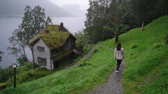 在挪威峡湾附近的村庄里散步的女人