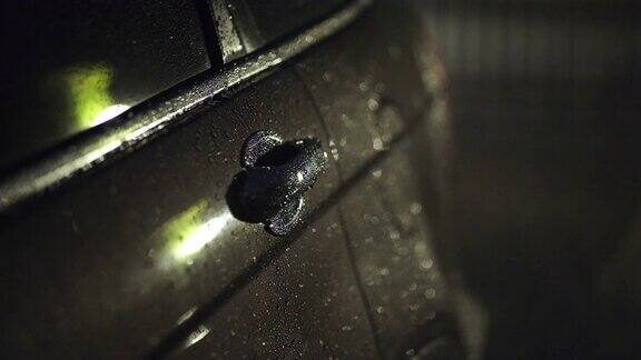 晚上在停车场的汽车上的雨滴