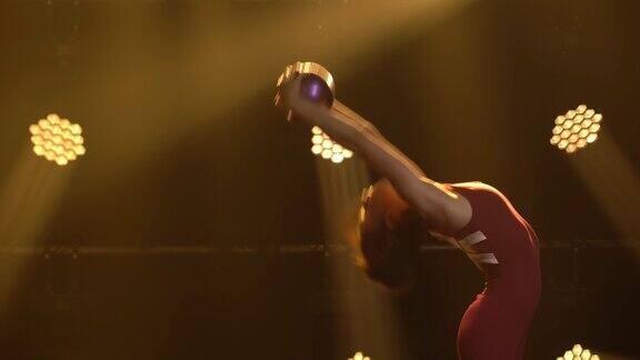 女体操运动员用球做杂技动作和伸展动作