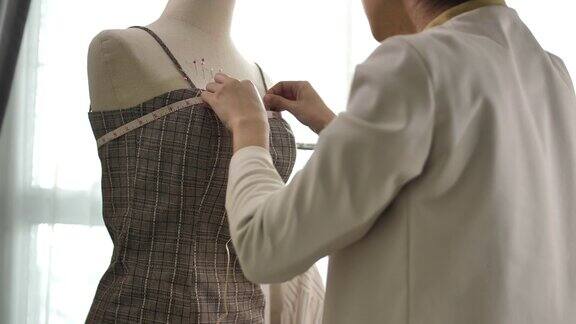 亚洲服装设计师的女人正在与测量工作