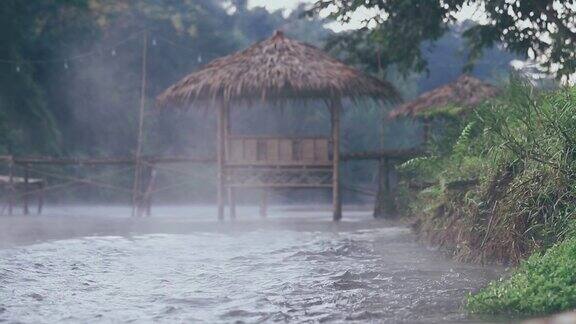 泰国冬季河流上的水汽以木亭和森林为背景在美丽的乡村自然中旅行