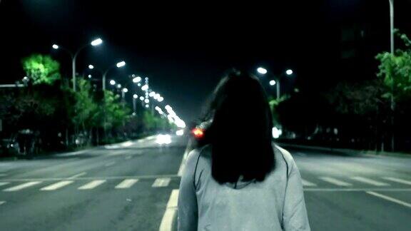 一个女人独自走在夜晚的街上