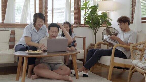 年轻幸福的家庭在客厅里使用笔记本电脑
