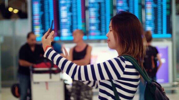 美女在机场用智能手机自拍