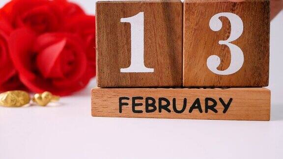 情人节的庆祝活动有红玫瑰花束结婚戒指和木制日历在2月14日孤立在白色的背景爱情和浪漫