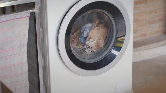 衣物在洗衣机中纺纱的慢镜头洗衣机门里面有可旋转的衣物