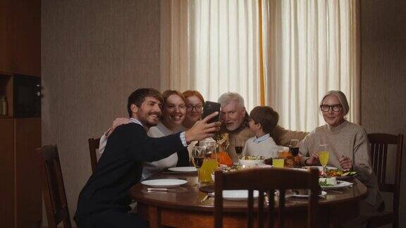 感恩节一家人坐在餐桌前用手机自拍