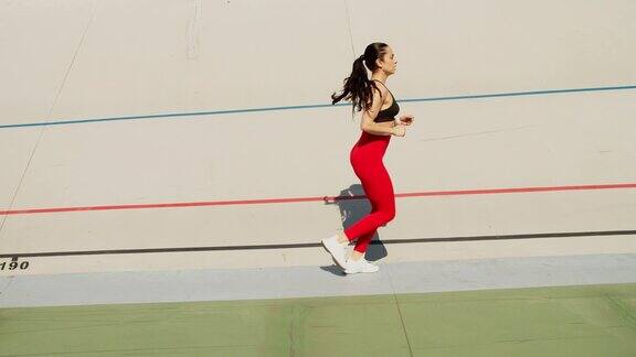 健康的女人在体育场跑道上慢跑女子跑步者以慢动作跑步