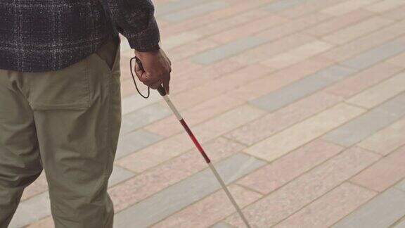街头拄拐杖的盲人