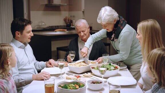 奶奶在家庭晚餐上做千层面