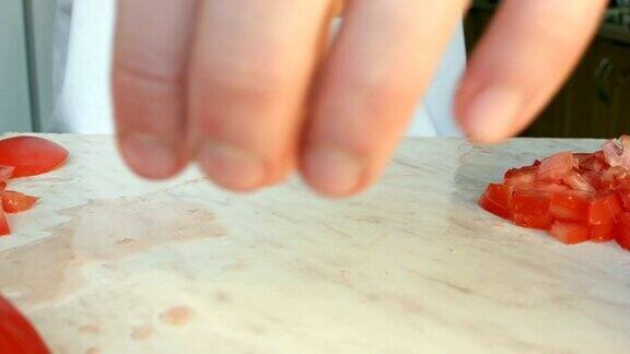 厨师用手切一个鲜红的番茄