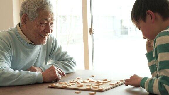 爷爷在家里和孙子下棋