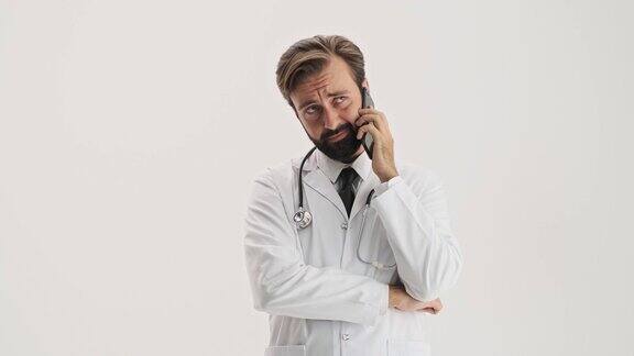 不高兴的男医生用听诊器在智能手机上打电话很烦人