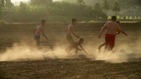 乡村的孩子们在阳光明媚的日子里踢足球