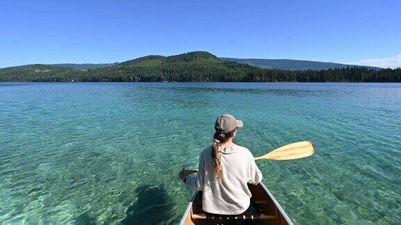 在美丽的山湖上划独木舟的女人