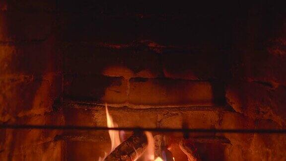 砖砌壁炉里温暖舒适的燃烧着的火靠近了