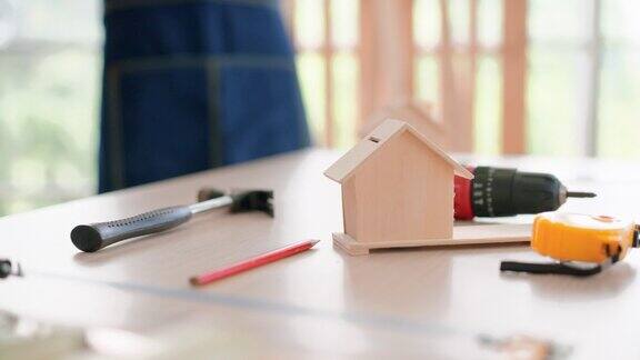 木匠工作工具和房屋模型放在工作间的桌子上供成人学习