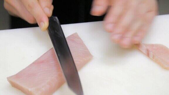 厨师的手正在切金枪鱼片做寿司